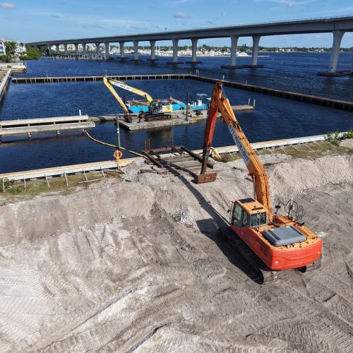 Aerial view of a coastal landscape with clear blue waters, sandy beaches, and lush green vegetation along the shoreline.